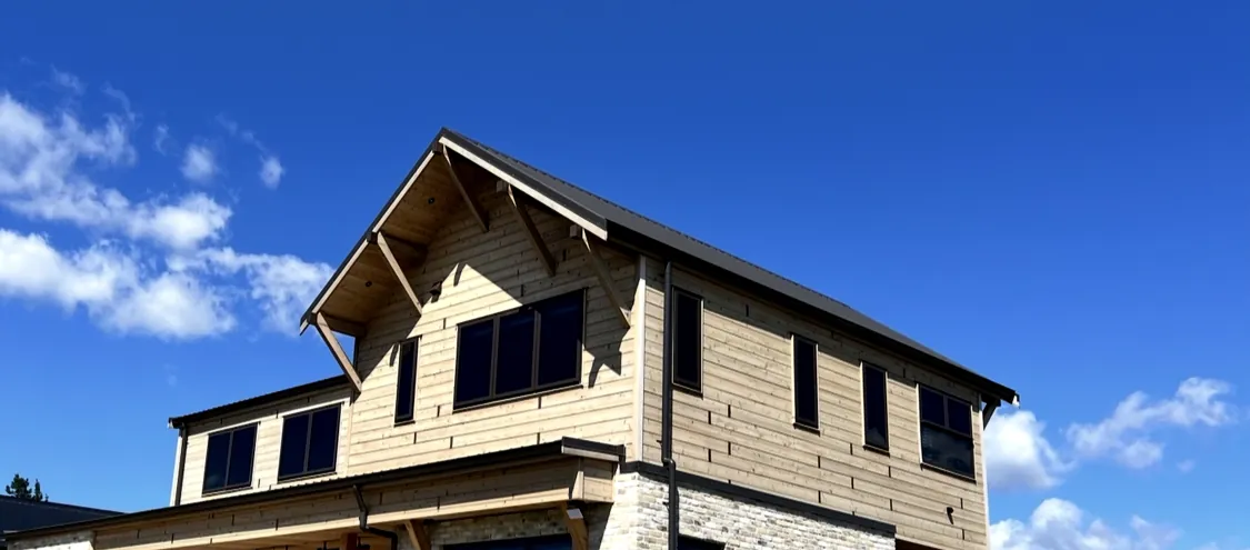 Timber gable and stone corner against blue sky